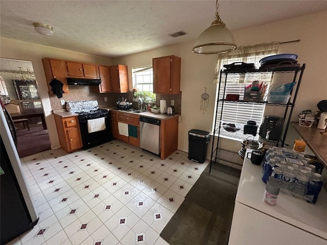 5546 Wellborn Creek Dr, Lithonia, GA 30058 - kitchen with black gas range oven, stainless steel dishwasher, under cabinet range hood, brown cabinetry, and a textured ceiling