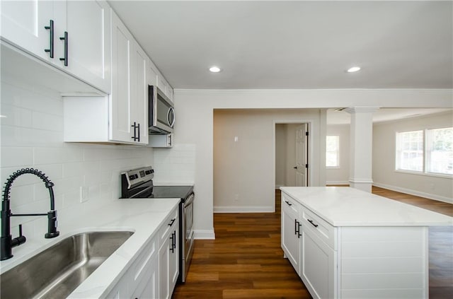 kitchen with sink, appliances with stainless steel finishes, dark wood-type flooring, and white cabinets