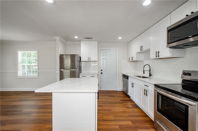 kitchen with baseboards, recessed lighting, dark wood-type flooring, a sink, and appliances with stainless steel finishes