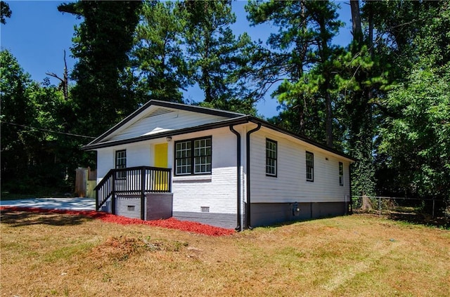 view of front facade featuring crawl space, fence, and a front lawn