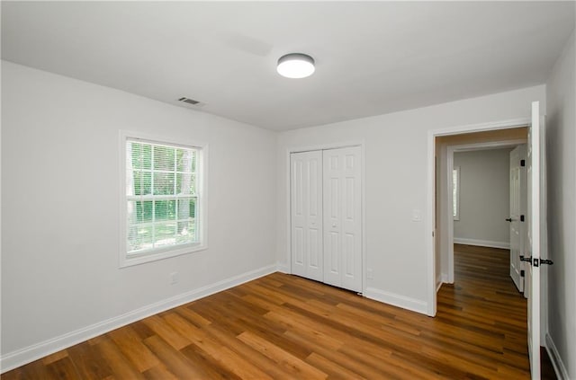 unfurnished bedroom featuring a closet and wood-type flooring