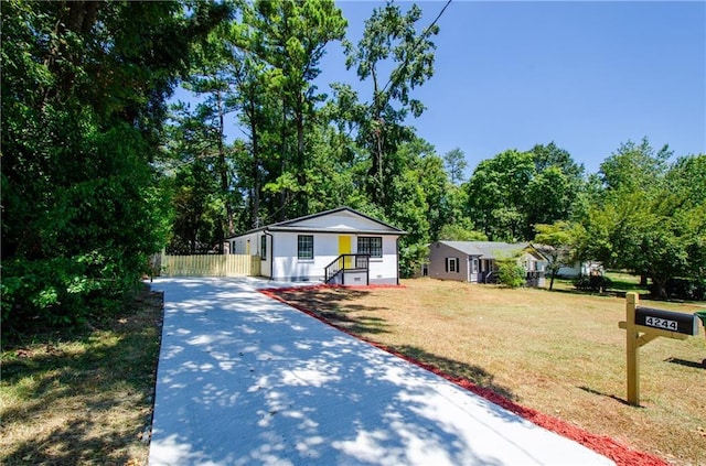 bungalow featuring fence, driveway, and a front lawn