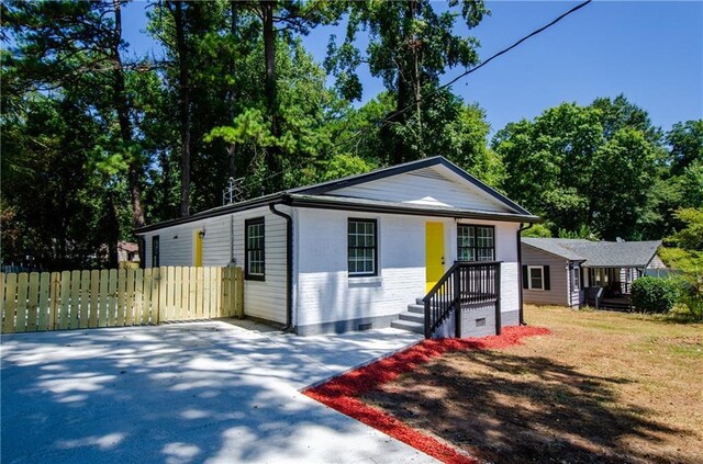 view of front of property with brick siding, fence, and crawl space