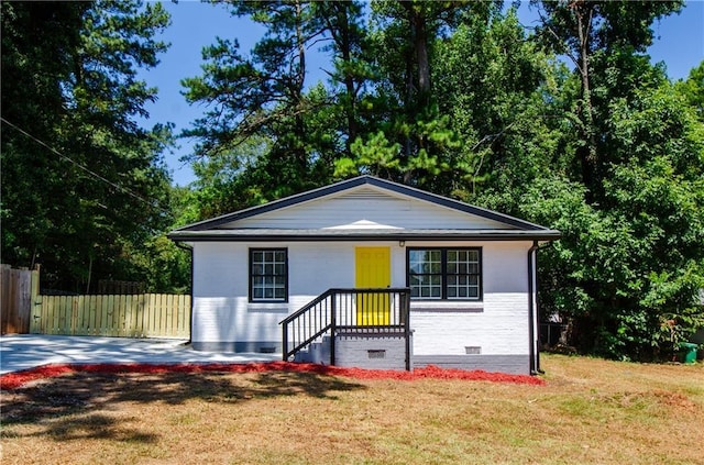 bungalow-style house featuring fence, a front yard, and crawl space