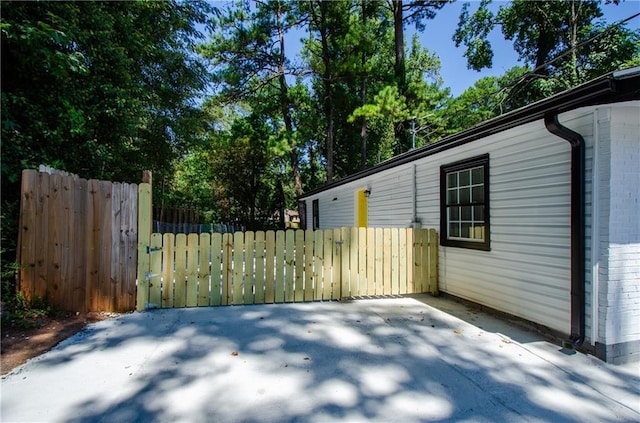view of property exterior with brick siding and fence