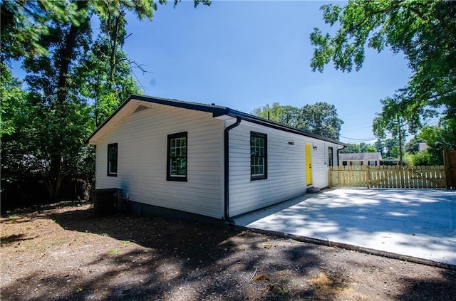 view of property exterior with fence and central AC unit