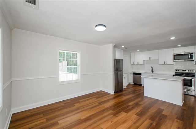 kitchen featuring sink, stainless steel appliances, white cabinets, crown molding, and dark hardwood / wood-style floors