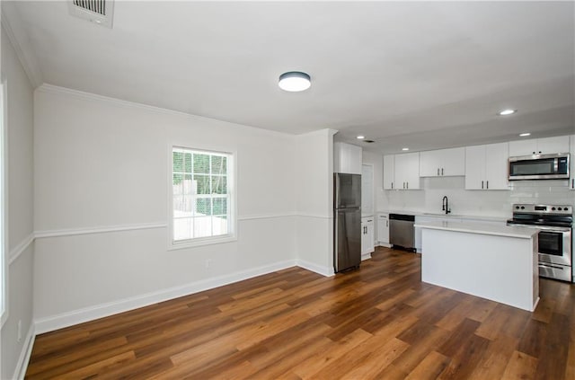 kitchen featuring baseboards, light countertops, a sink, dark wood finished floors, and stainless steel appliances