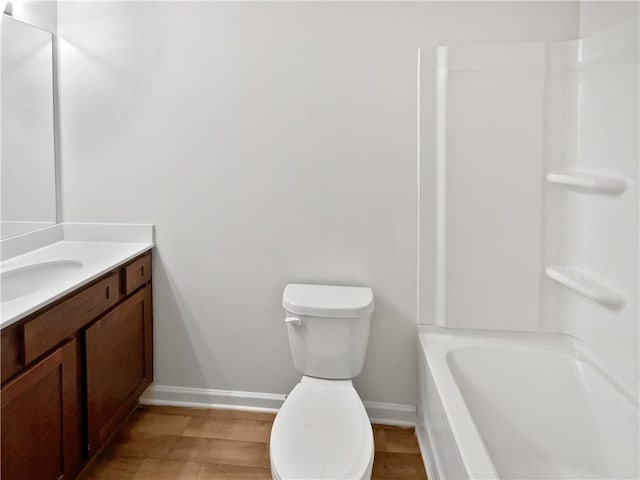 full bathroom with wood-type flooring, vanity, bathtub / shower combination, and toilet