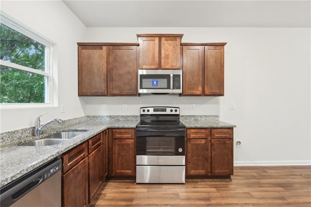 4001 Avalon Rd SW, Atlanta, GA 30331 - kitchen featuring a sink, appliances with stainless steel finishes, light wood-style floors, and light stone countertops