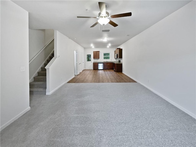 4001 Avalon Rd SW, Atlanta, GA 30331 - unfurnished living room with a ceiling fan, visible vents, baseboards, dark colored carpet, and stairs