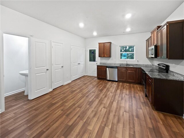 kitchen with dark hardwood / wood-style flooring, sink, and stainless steel appliances