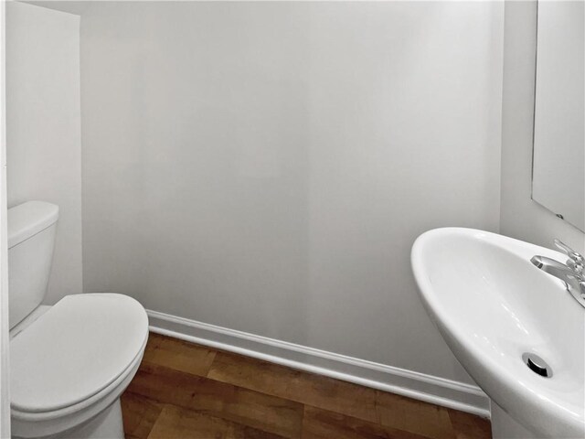 bathroom featuring wood-type flooring, sink, and toilet