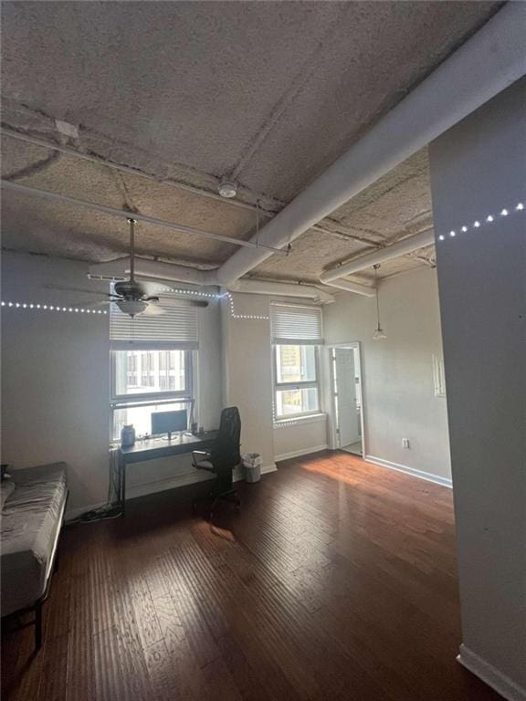 interior space with a healthy amount of sunlight, ceiling fan, beamed ceiling, and hardwood / wood-style floors