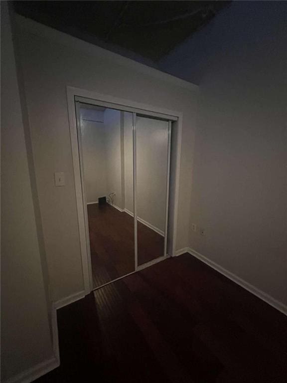 unfurnished bedroom featuring a closet and dark hardwood / wood-style floors