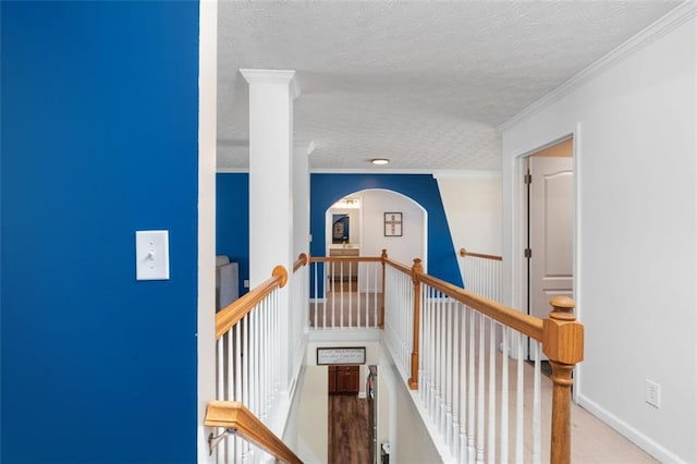 hall featuring ornamental molding and a textured ceiling