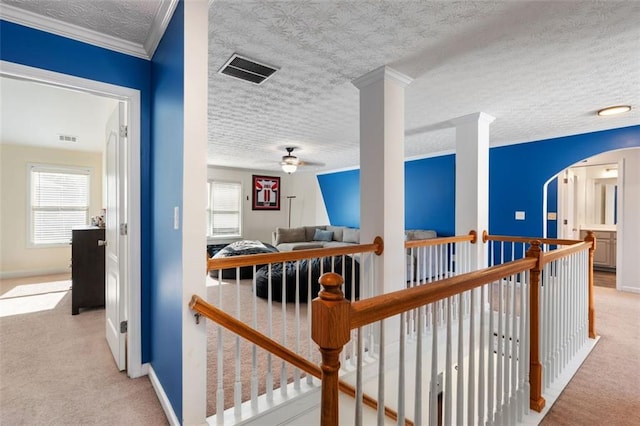 corridor with crown molding, a wealth of natural light, and light colored carpet