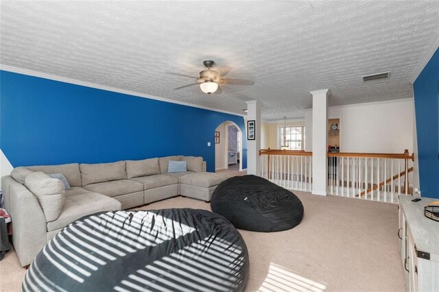 carpeted living room with ornamental molding, ceiling fan, and a textured ceiling