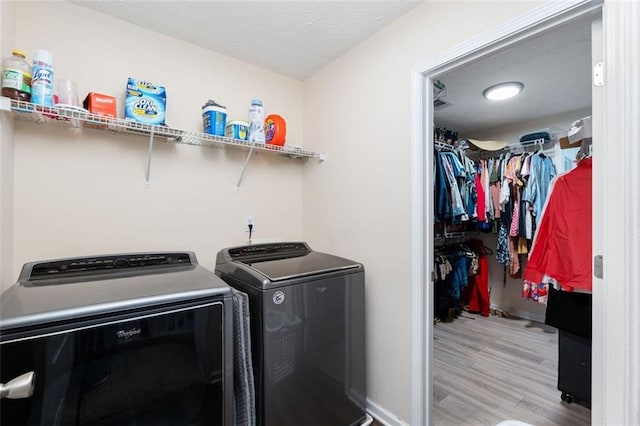 laundry area with washer and dryer and light wood-type flooring