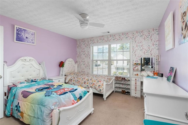 carpeted bedroom featuring a textured ceiling and ceiling fan