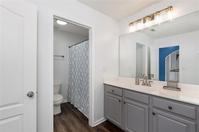 bathroom with wood-type flooring, toilet, a shower with shower curtain, and vanity