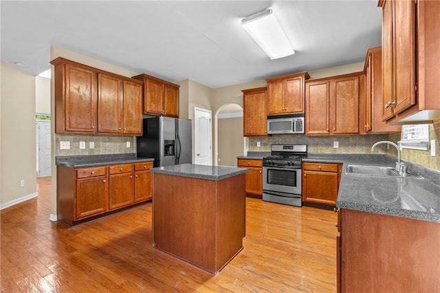 3039 Tuscan Ridge Dr, Snellville, GA 30039 - kitchen featuring stainless steel appliances, a sink, backsplash, and arched walkways