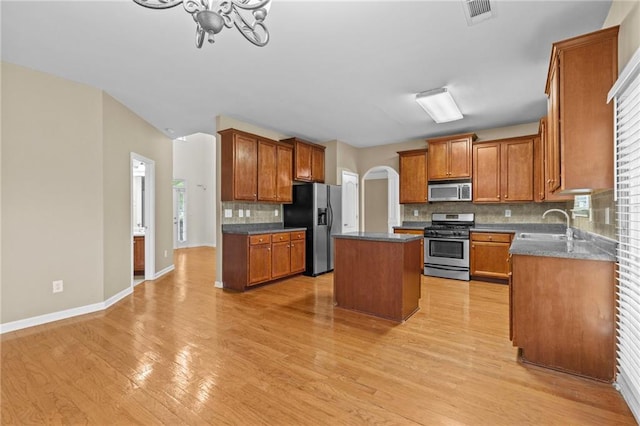 3039 Tuscan Ridge Dr, Snellville, GA 30039 - kitchen featuring stainless steel appliances, a kitchen island, a sink, backsplash, and light wood finished floors