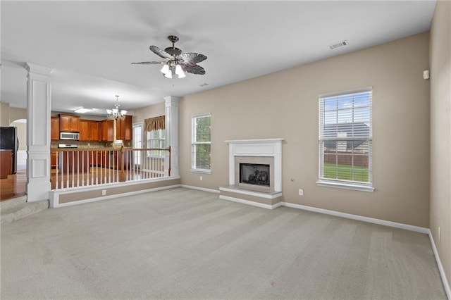 3039 Tuscan Ridge Dr, Snellville, GA 30039 - unfurnished living room with ornate columns, light carpet, a fireplace with raised hearth, a chandelier, and baseboards