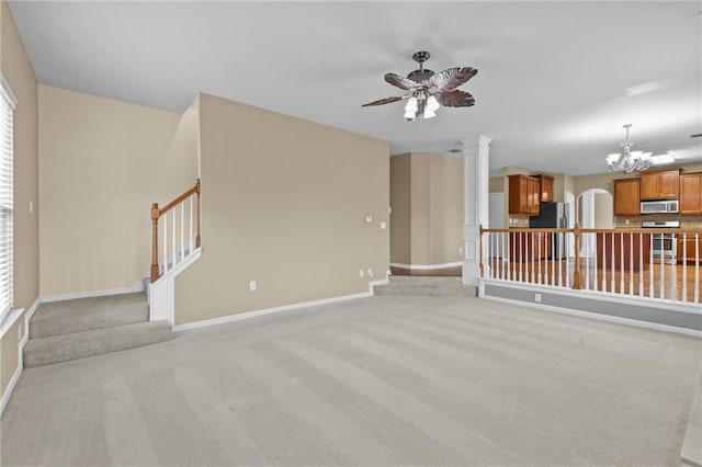 3039 Tuscan Ridge Dr, Snellville, GA 30039 - unfurnished living room with a chandelier, decorative columns, stairs, ceiling fan, and baseboards