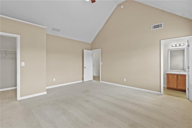 3039 Tuscan Ridge Dr, Snellville, GA 30039 - unfurnished bedroom featuring high vaulted ceiling, a walk in closet, light carpet, and baseboards