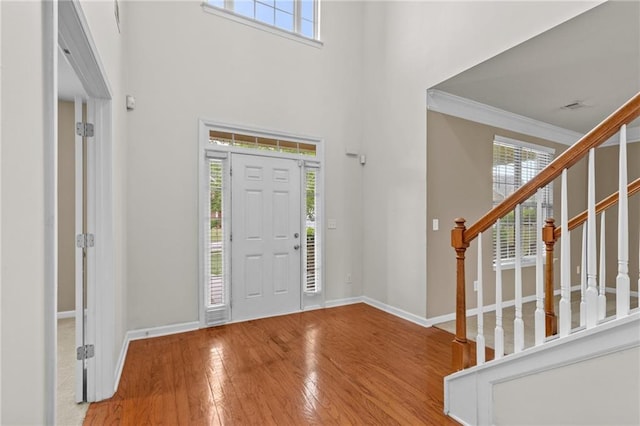 3039 Tuscan Ridge Dr, Snellville, GA 30039 - entryway with wood-type flooring, baseboards, stairs, ornamental molding, and a high ceiling