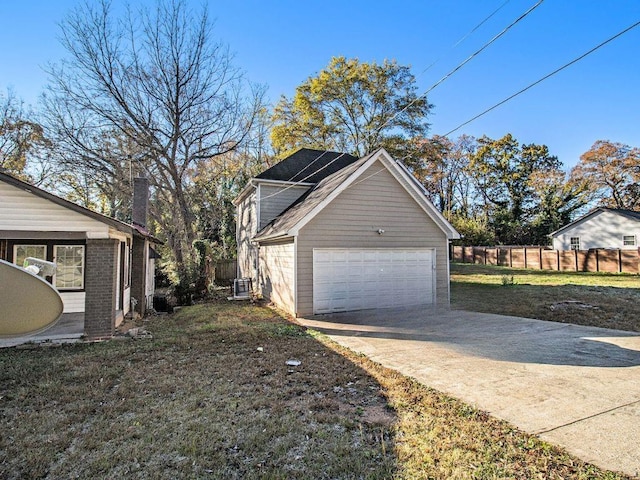 garage featuring a yard and central AC unit