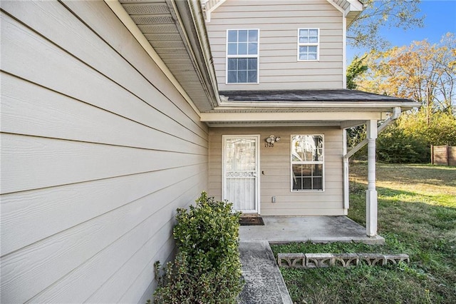 view of exterior entry featuring a lawn