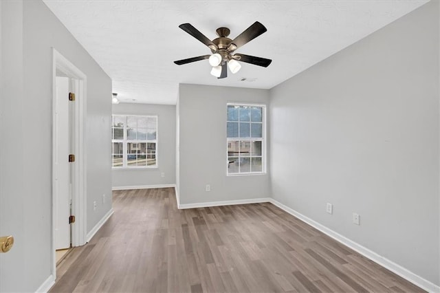 spare room with ceiling fan and light wood-type flooring