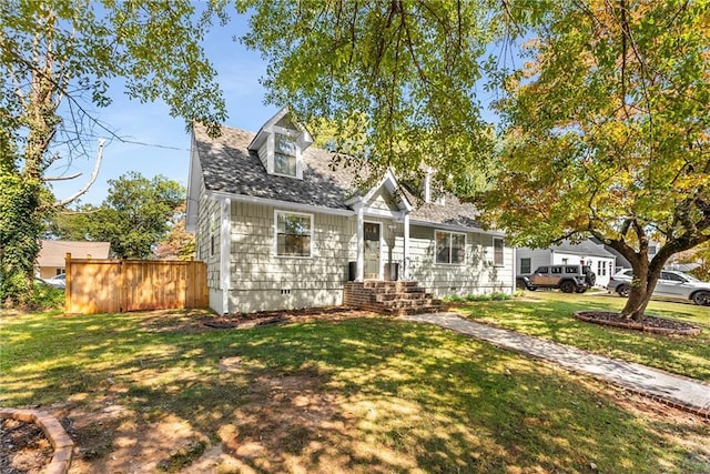 cape cod house with crawl space, a shingled roof, and a front lawn