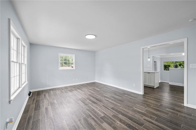 empty room with dark wood finished floors and baseboards