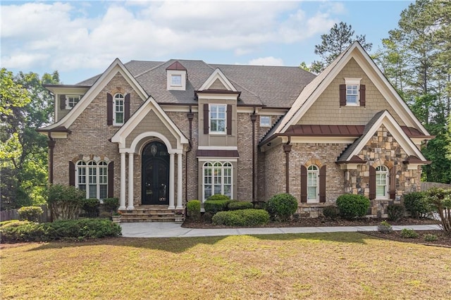 view of front facade with a front lawn, brick siding, a standing seam roof, and roof with shingles