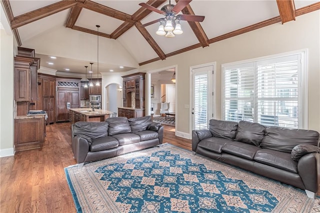 living area featuring ceiling fan, wood finished floors, high vaulted ceiling, beamed ceiling, and baseboards