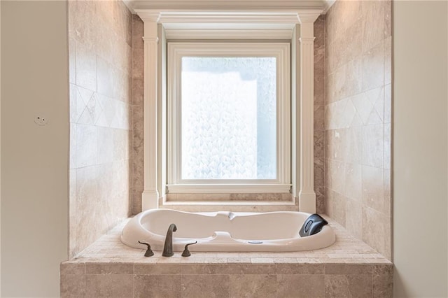 bathroom featuring healthy amount of natural light, a garden tub, and decorative columns