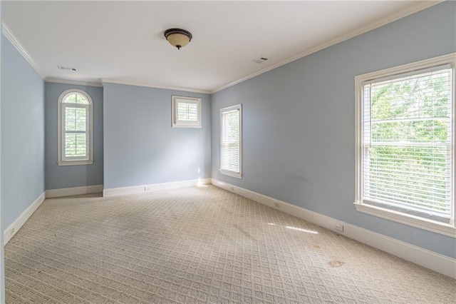 carpeted empty room featuring crown molding and baseboards