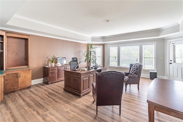office area featuring a tray ceiling, wood finished floors, crown molding, and baseboards