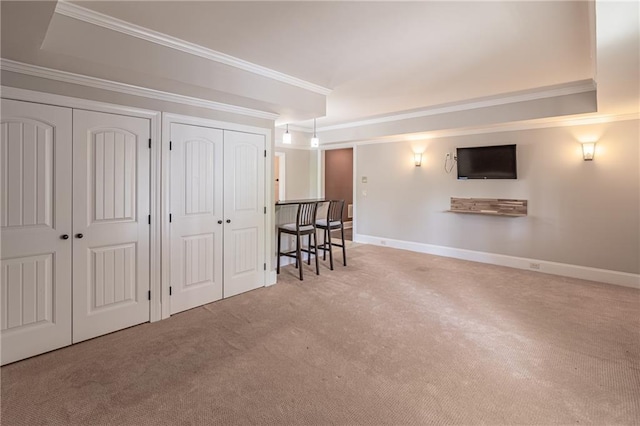 below grade area with carpet flooring, ornamental molding, and baseboards