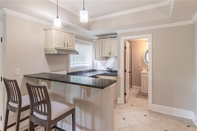 kitchen with a kitchen breakfast bar, a peninsula, hanging light fixtures, dark stone counters, and light tile patterned flooring