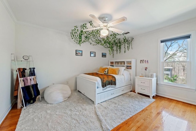 bedroom featuring light wood-type flooring and crown molding