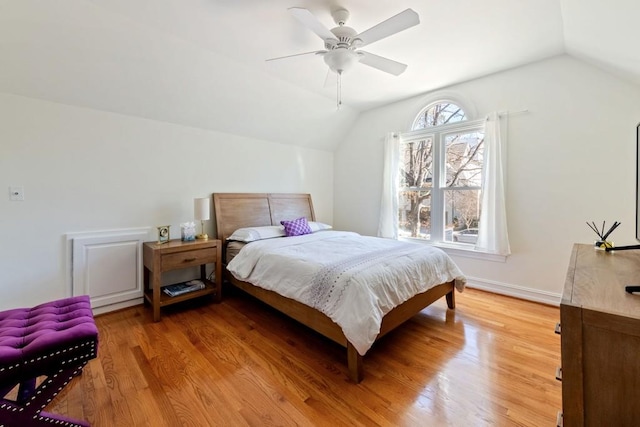 bedroom featuring lofted ceiling, baseboards, ceiling fan, and light wood finished floors