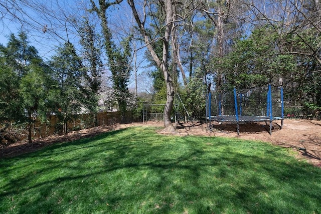 view of yard featuring a trampoline and a fenced backyard