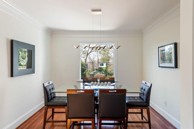 dining area with ornamental molding, baseboards, and wood finished floors