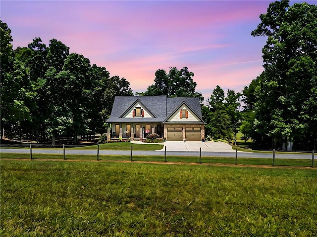 view of front of home featuring a garage and a yard