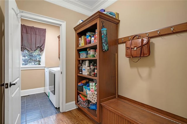 washroom featuring washing machine and clothes dryer, ornamental molding, and dark hardwood / wood-style floors