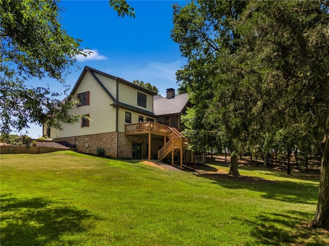 rear view of house with a wooden deck and a yard